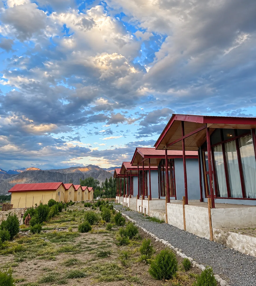 Guest cottages beneath a dramatic Skardu sky